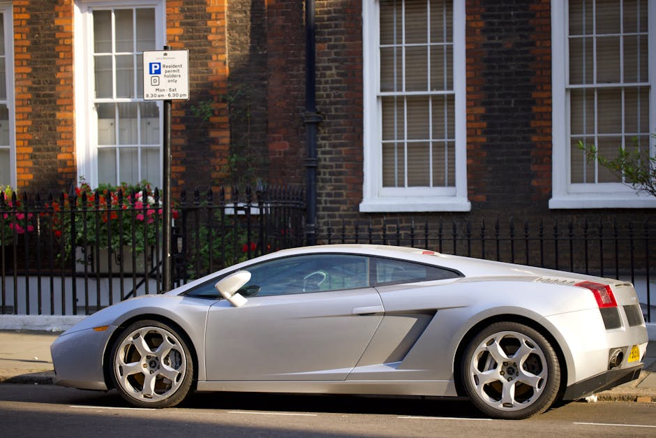 A street scene in Fulham during daytime with parked cars lining both sides of the cobbled road, including a mix of dark and metallic vehicles. On the right side, a building under construction is visib
